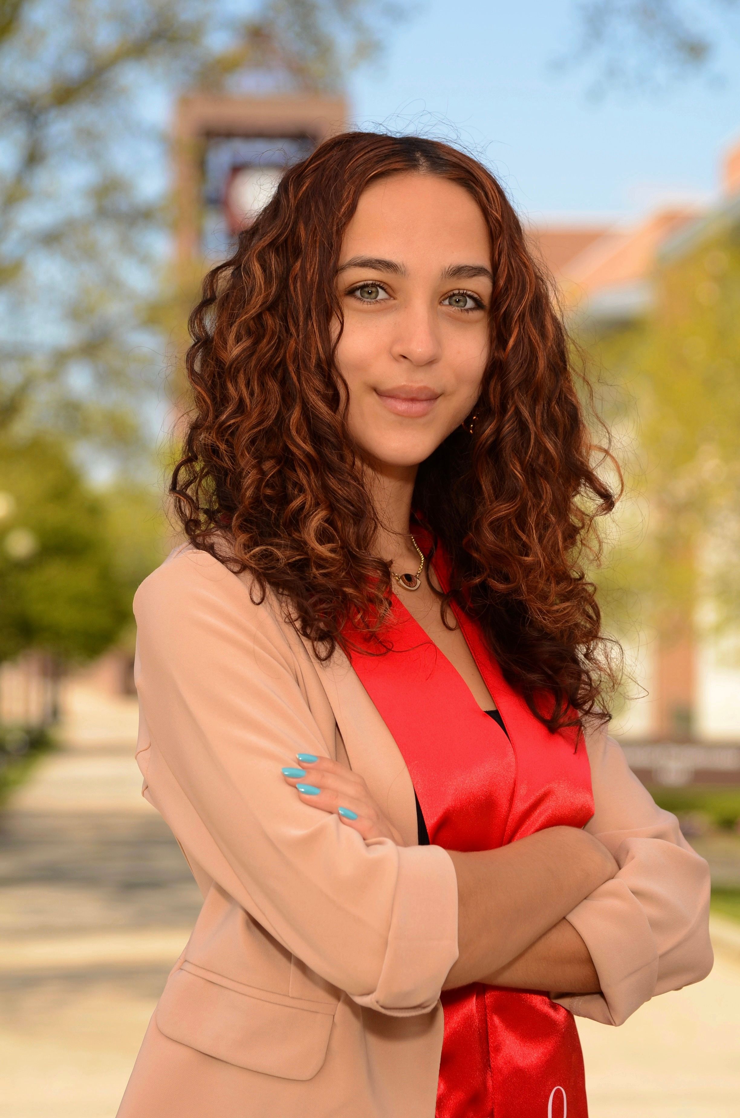 Georgie Humphries, marine biogeochemist, standing on a tree-lined campus walkway.